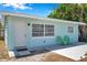 Charming single-story home with a light blue exterior, white trim, and a cozy front entrance with green chairs at 5214 11Th S Ave, Gulfport, FL 33707