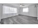 Spacious living room with wood-look floors, sheer curtains, and ample natural light from large windows at 5214 11Th S Ave, Gulfport, FL 33707