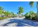 Gated community entrance with lush landscaping and tropical palm trees at 5403 Mang Pl, Sarasota, FL 34238