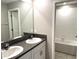 A clean bathroom with double sinks, granite counters, tile flooring and tub shower at 5430 Amaryllis Garden St, Apollo Beach, FL 33572