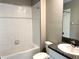 A bright bathroom featuring a shower-tub combo, granite countertops and tile flooring at 5430 Amaryllis Garden St, Apollo Beach, FL 33572