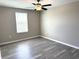 This bedroom includes a ceiling fan, a window and gray laminate floors at 5430 Amaryllis Garden St, Apollo Beach, FL 33572