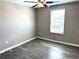 Bedroom features a window, ceiling fan and gray laminate flooring at 5430 Amaryllis Garden St, Apollo Beach, FL 33572