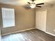 An empty bedroom with a window, gray laminate flooring and a ceiling fan at 5430 Amaryllis Garden St, Apollo Beach, FL 33572