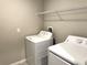 Convenient laundry room equipped with a washer, dryer, and a wire rack shelf for storage and organization at 5430 Amaryllis Garden St, Apollo Beach, FL 33572