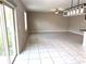 Open living area with neutral walls, tile flooring, and sliding glass doors at 5430 Amaryllis Garden St, Apollo Beach, FL 33572