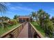 Walk the wooden path to the resident clubhouse, featuring lush landscaping and charming exterior at 5625 15Th Ave W, Bradenton, FL 34209