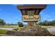 Welcome home to Meadowcroft, featuring a stone-lined entrance and welcoming signage surrounded by greenery at 5625 15Th Ave W, Bradenton, FL 34209