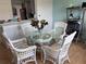 Bright dining area featuring a glass table, white wicker chairs, and stylish decor at 5741 Soldier Cir # 202, Sarasota, FL 34233