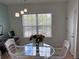Dining area with glass table, white chairs, modern lighting, and large window at 5741 Soldier Cir # 202, Sarasota, FL 34233
