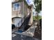 Side view of a beige condo unit with stairs and black metal railings at 5741 Soldier Cir # 202, Sarasota, FL 34233