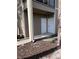 Tan condo exterior showcasing two doors and a glimpse of a tree, secured by a black fence at 5741 Soldier Cir # 202, Sarasota, FL 34233
