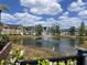 Scenic pond view surrounded by colorful townhomes and lush landscaping in a charming neighborhood at 5741 Soldier Cir # 202, Sarasota, FL 34233