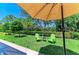 Beautiful backyard with lush lawn, landscaping, and seating under the shade of an umbrella at 5957 Amberly Dr, Bradenton, FL 34208