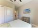 Comfortable bedroom featuring light walls, a ceiling fan, ample closet space, and a mounted flat screen TV at 5957 Amberly Dr, Bradenton, FL 34208
