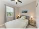 Cozy bedroom with a ceiling fan, decorative lamps, neutral walls, and a peaceful window view at 5957 Amberly Dr, Bradenton, FL 34208