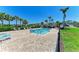 Community pool surrounded by lounge chairs, lush landscaping, and clear blue skies at 5957 Amberly Dr, Bradenton, FL 34208