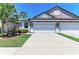 Charming home featuring a well-manicured lawn, light purple walls, and a spacious two-car garage at 5957 Amberly Dr, Bradenton, FL 34208