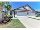 Charming home featuring a well-manicured lawn, light purple walls, and a spacious two-car garage at 5957 Amberly Dr, Bradenton, FL 34208