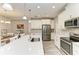 Bright kitchen featuring an island with seating and stainless steel appliances that opens to the dining area at 5957 Amberly Dr, Bradenton, FL 34208