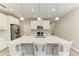 Bright kitchen featuring an island with a quartz countertop, stainless steel appliances, and white cabinets at 5957 Amberly Dr, Bradenton, FL 34208