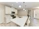 Bright kitchen featuring an island with a quartz countertop, stainless steel appliances, and white cabinets at 5957 Amberly Dr, Bradenton, FL 34208
