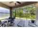 Relaxing screened patio with a ceiling fan, seating, and a view of the landscaped backyard at 5957 Amberly Dr, Bradenton, FL 34208