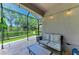 The screened patio features comfortable seating and tranquil views of the lush backyard at 5957 Amberly Dr, Bradenton, FL 34208