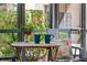 Cozy lanai with chairs, table, flowers, and nature views at 6157 E Midnight Pass Rd # B51, Sarasota, FL 34242