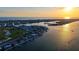 Aerial view of coastal neighborhood homes with waterfront access and golf course during a colorful sunset at 621 Ivanhoe Ln, Holmes Beach, FL 34217