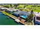 Aerial view of a home with a screened pool, canal access, and dock at 621 Ivanhoe Ln, Holmes Beach, FL 34217