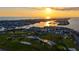 Panoramic aerial view of a coastal community, showcasing a golf course and expansive waterfront homes at sunset at 621 Ivanhoe Ln, Holmes Beach, FL 34217