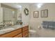 Cozy bathroom with granite counters, a decorative wreath, and framed floral art pieces at 621 Ivanhoe Ln, Holmes Beach, FL 34217