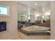 Luxurious bathroom featuring a jetted tub, granite surround, and mirrored walls at 621 Ivanhoe Ln, Holmes Beach, FL 34217