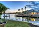 Picturesque evening view of the private dock with a boat lift, providing easy access to the water at 621 Ivanhoe Ln, Holmes Beach, FL 34217