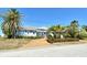 Charming single-story home with a well-manicured lawn and mature palm trees at 621 Ivanhoe Ln, Holmes Beach, FL 34217