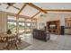 Expansive living room featuring wood beam ceilings, large windows, and tile flooring at 621 Ivanhoe Ln, Holmes Beach, FL 34217