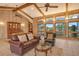 Cozy living room featuring wood paneling, large windows, and comfortable seating arrangements at 621 Ivanhoe Ln, Holmes Beach, FL 34217