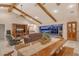Open-concept living and dining area with beamed ceilings and a view of the outdoor pool and waterfront at 621 Ivanhoe Ln, Holmes Beach, FL 34217