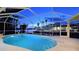 Enclosed pool area with a view of the waterfront, trees and houses during the night at 621 Ivanhoe Ln, Holmes Beach, FL 34217