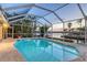 Enclosed pool area with waterfront views, lush tropical plants, and direct access to the canal creating serene relaxation at 621 Ivanhoe Ln, Holmes Beach, FL 34217