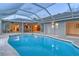 Bright screened pool with a view to the home's interior, including a dining area and living room, providing seamless indoor-outdoor living at 621 Ivanhoe Ln, Holmes Beach, FL 34217