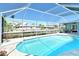Enclosed pool offering waterfront views and access to the canal, enhanced by a screen enclosure for outdoor enjoyment at 621 Ivanhoe Ln, Holmes Beach, FL 34217