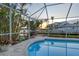Screened pool at sunset with canal views and lush landscaping, creating a relaxing outdoor oasis with stunning natural beauty at 621 Ivanhoe Ln, Holmes Beach, FL 34217