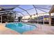 Enclosed pool overlooking a beautiful waterfront view with palm trees at sunset at 621 Ivanhoe Ln, Holmes Beach, FL 34217