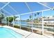Covered pool featuring a screened enclosure with waterfront views and direct access to the canal at 621 Ivanhoe Ln, Holmes Beach, FL 34217