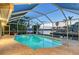 Screened pool at dusk providing a tranquil setting with lush greenery and waterfront views, creating a relaxing outdoor retreat at 621 Ivanhoe Ln, Holmes Beach, FL 34217