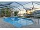 Beautiful caged pool overlooks a wide canal and lush tropical landscaping at 621 Ivanhoe Ln, Holmes Beach, FL 34217