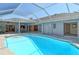 Bright screened pool with a view to the home's interior, including a dining area and living room, providing seamless indoor-outdoor living at 621 Ivanhoe Ln, Holmes Beach, FL 34217