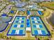 Aerial view of community pickleball, tennis, and bocce ball courts near the pool, amenity center and lake at 6248 Fish Eagle Ct, Nokomis, FL 34275